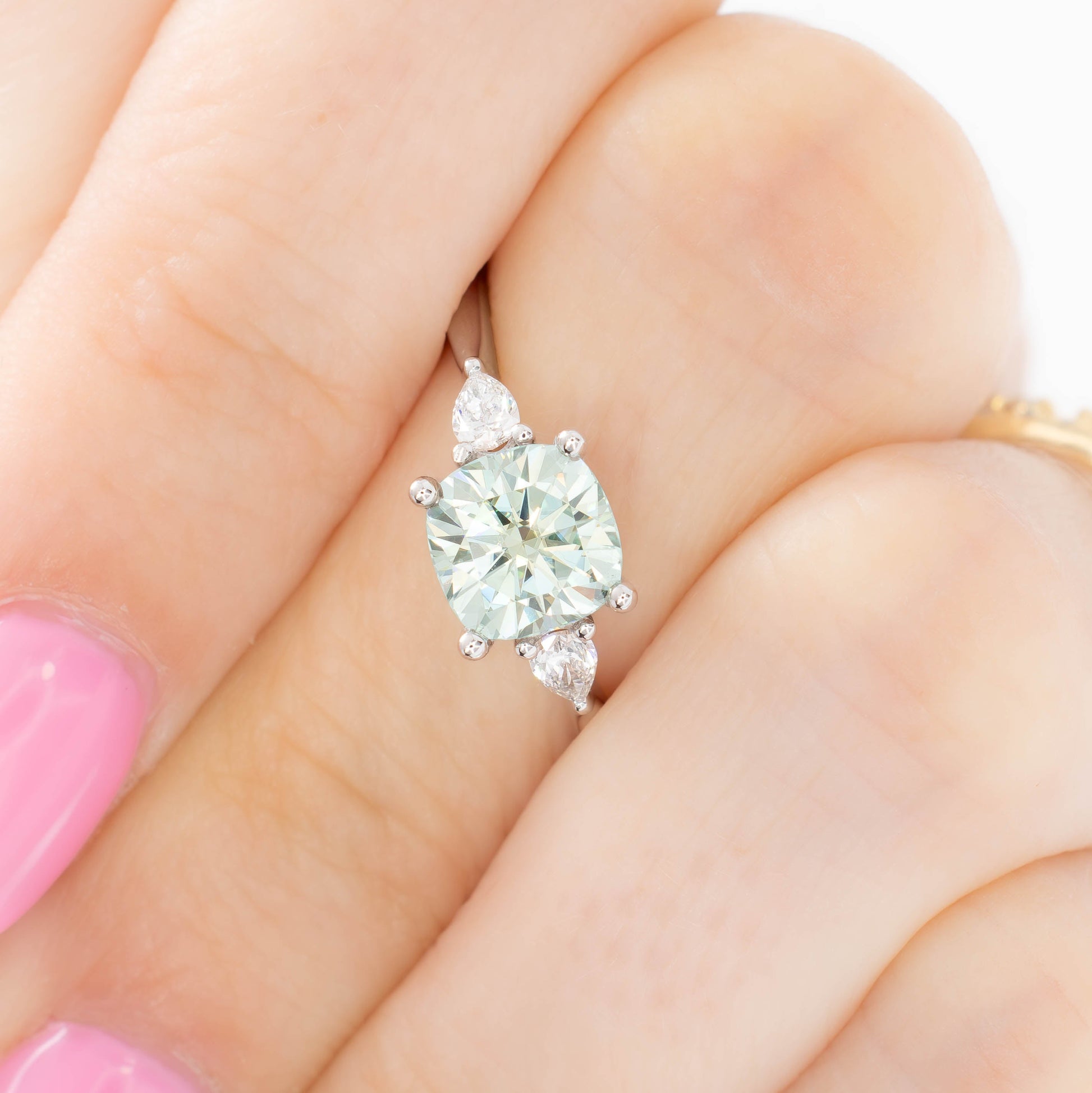 lacey three stone ring with cushion blue-green moissanite