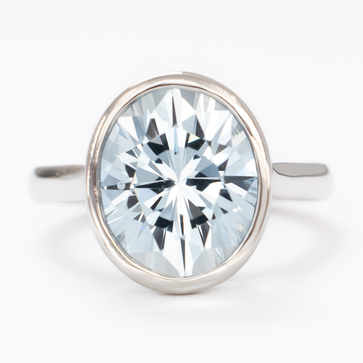 lessie bezel solitaire ring in white gold with oval light blue lab sapphire