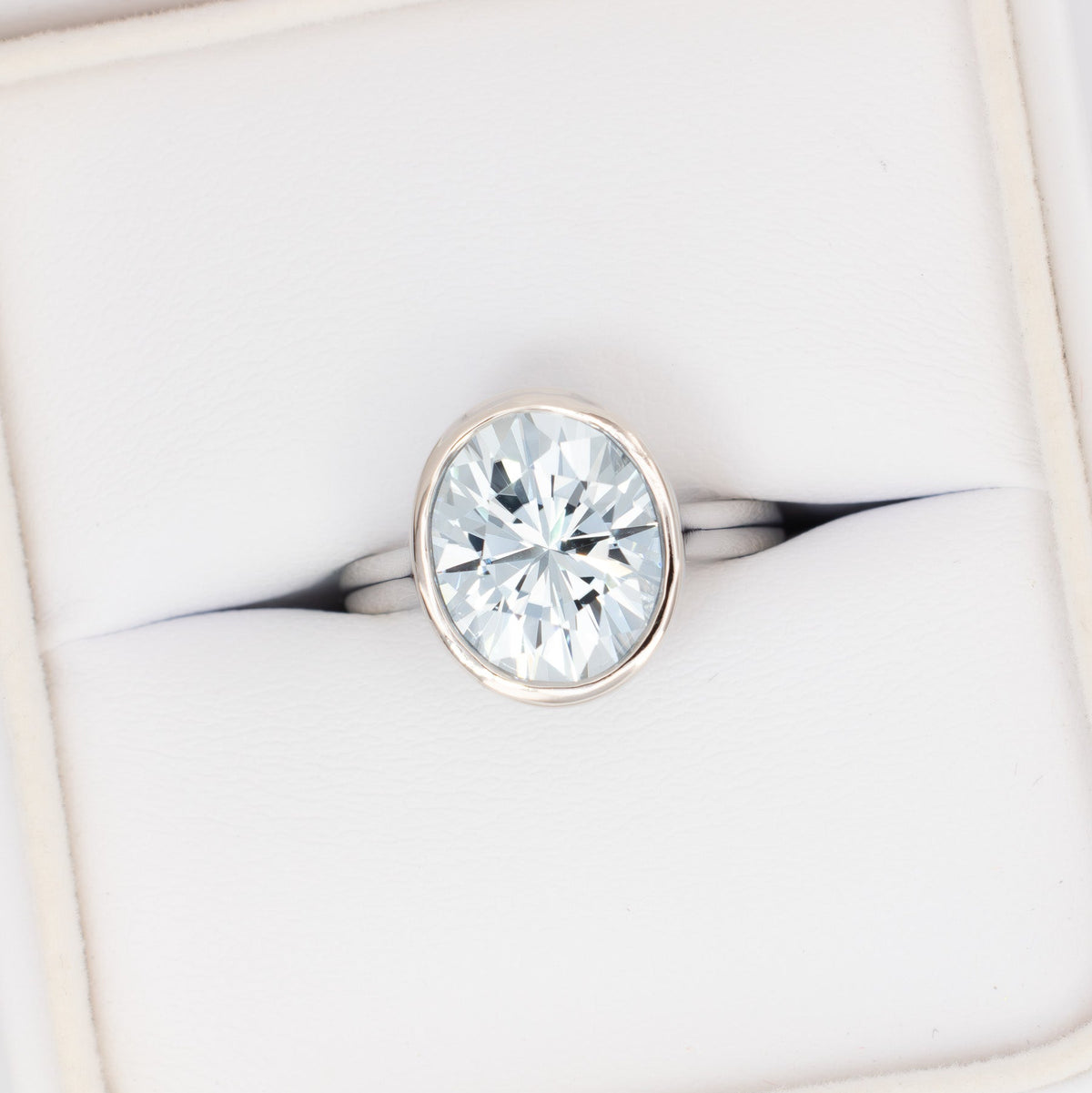 lessie bezel solitaire ring in white gold with oval light blue lab sapphire