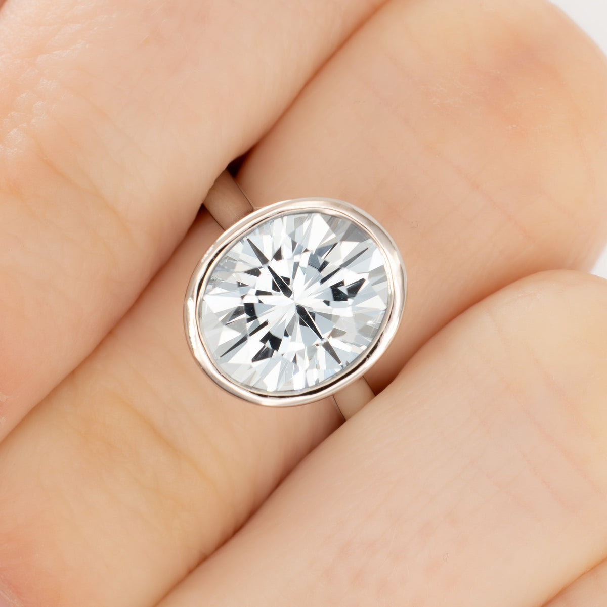 lessie bezel solitaire ring in white gold with oval light blue lab sapphire