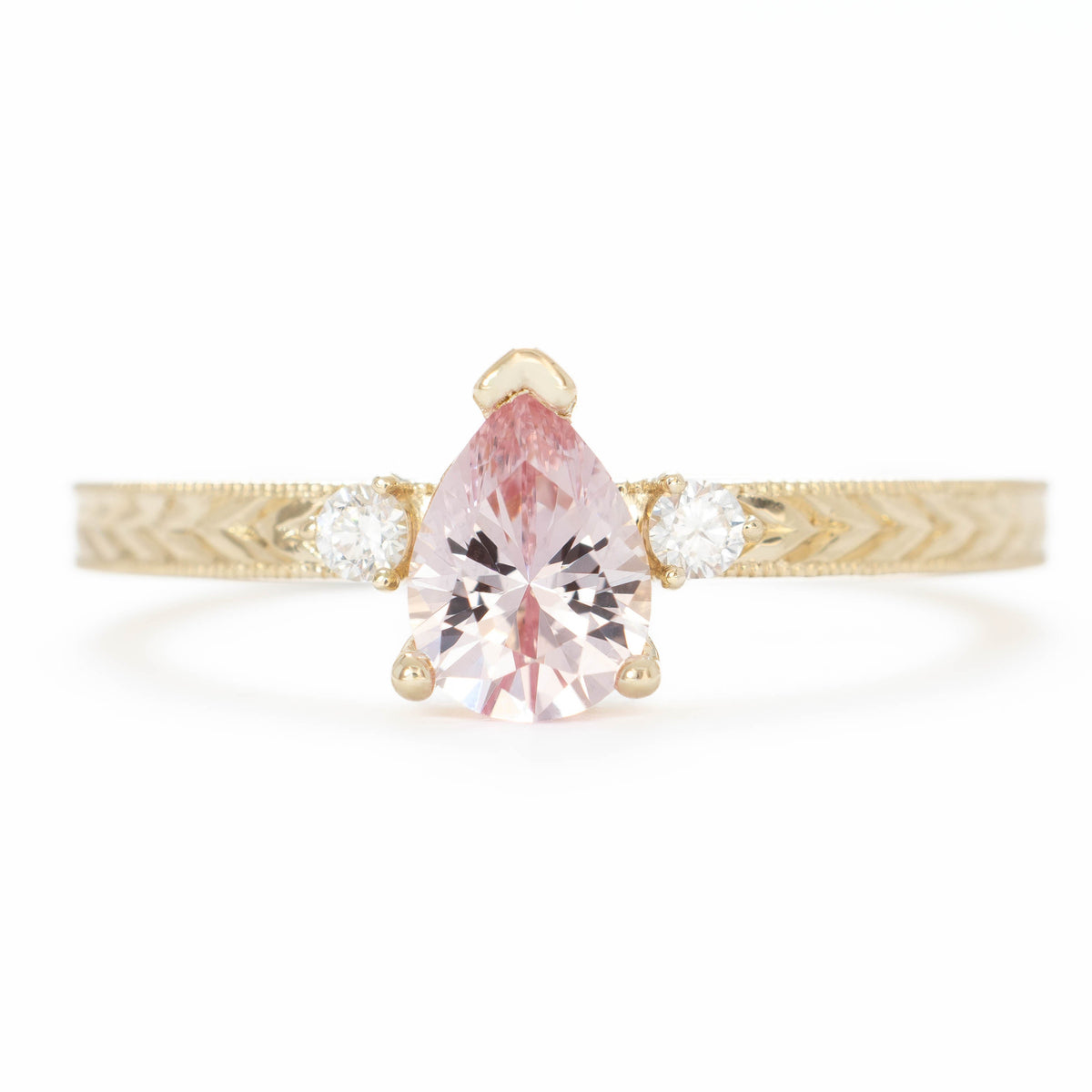 meera three stone ring with chevron detail in yellow gold and pink lab sapphire pear