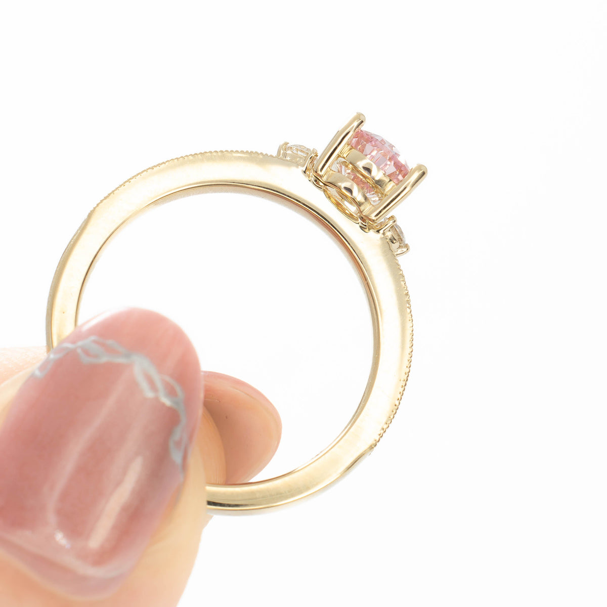 meera three stone ring with chevron detail in yellow gold and pink lab sapphire pear