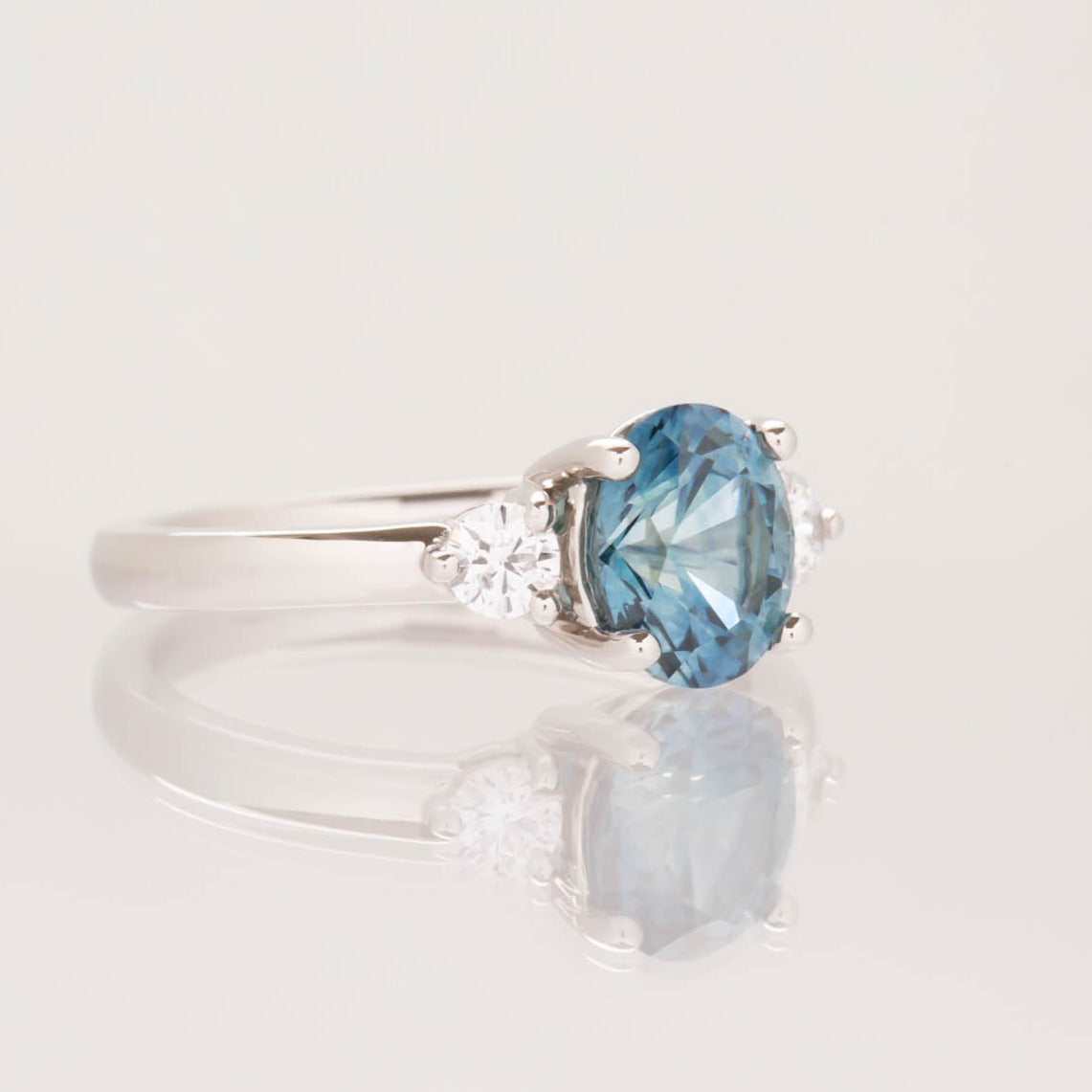 three stone engagement ring with montana sapphire oval