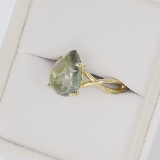 green pear cabochon tourmaline in yellow gold infinity ring