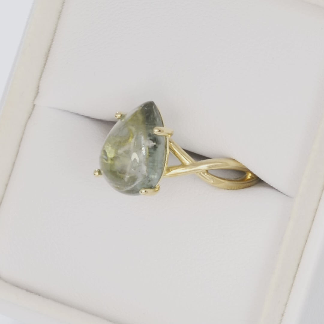 green pear cabochon tourmaline in yellow gold infinity ring