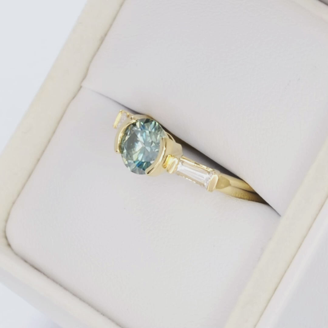 ezri three stone ring in yellow gold with blue-green round moissanite