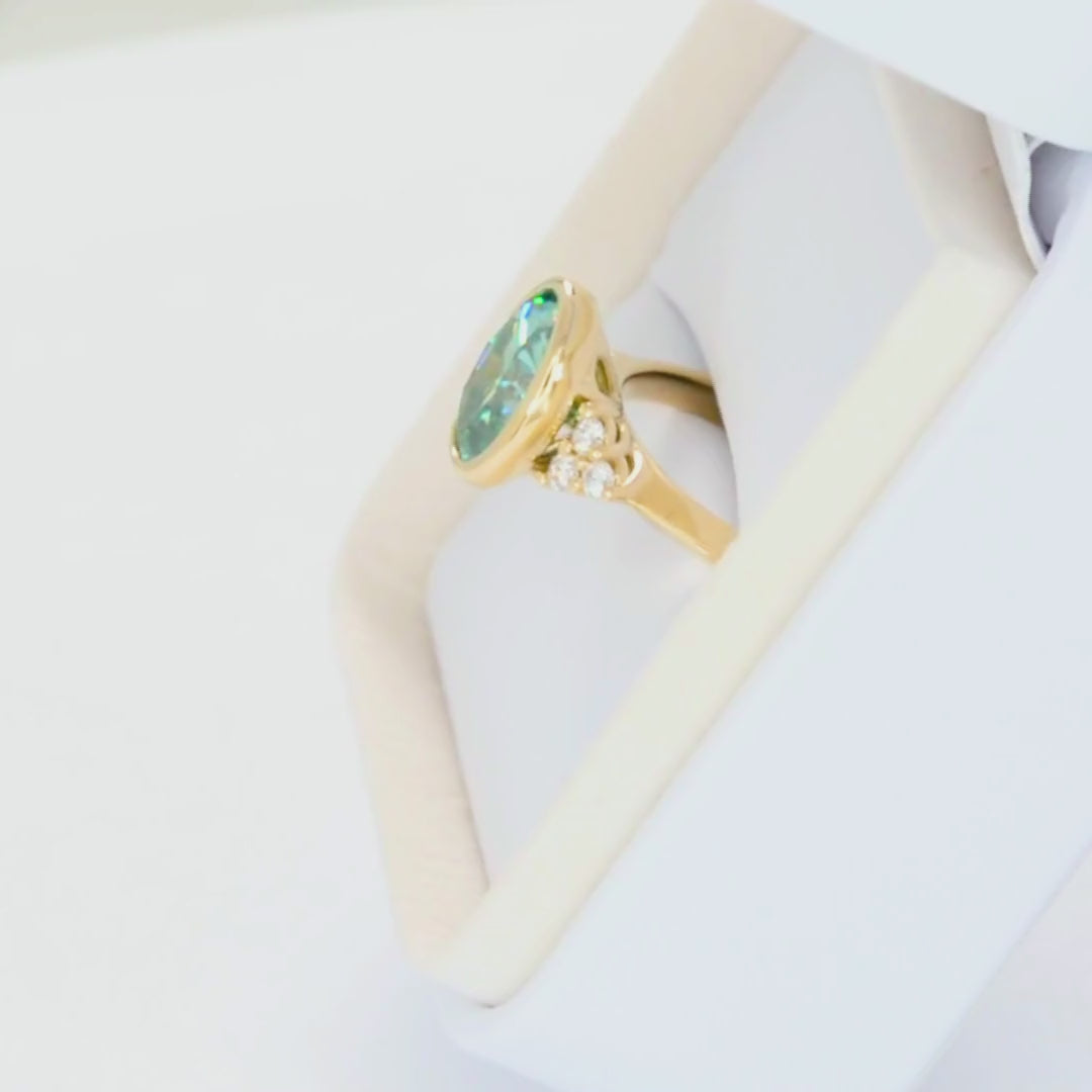 alinta bezel set accented ring in yellow gold with green moissanite oval