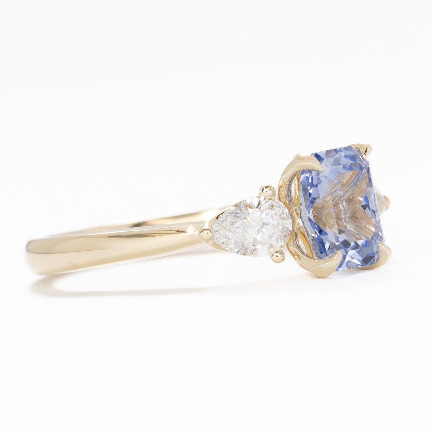 tawnee three stone engagement ring in yellow gold and blue lab sapphire radiant