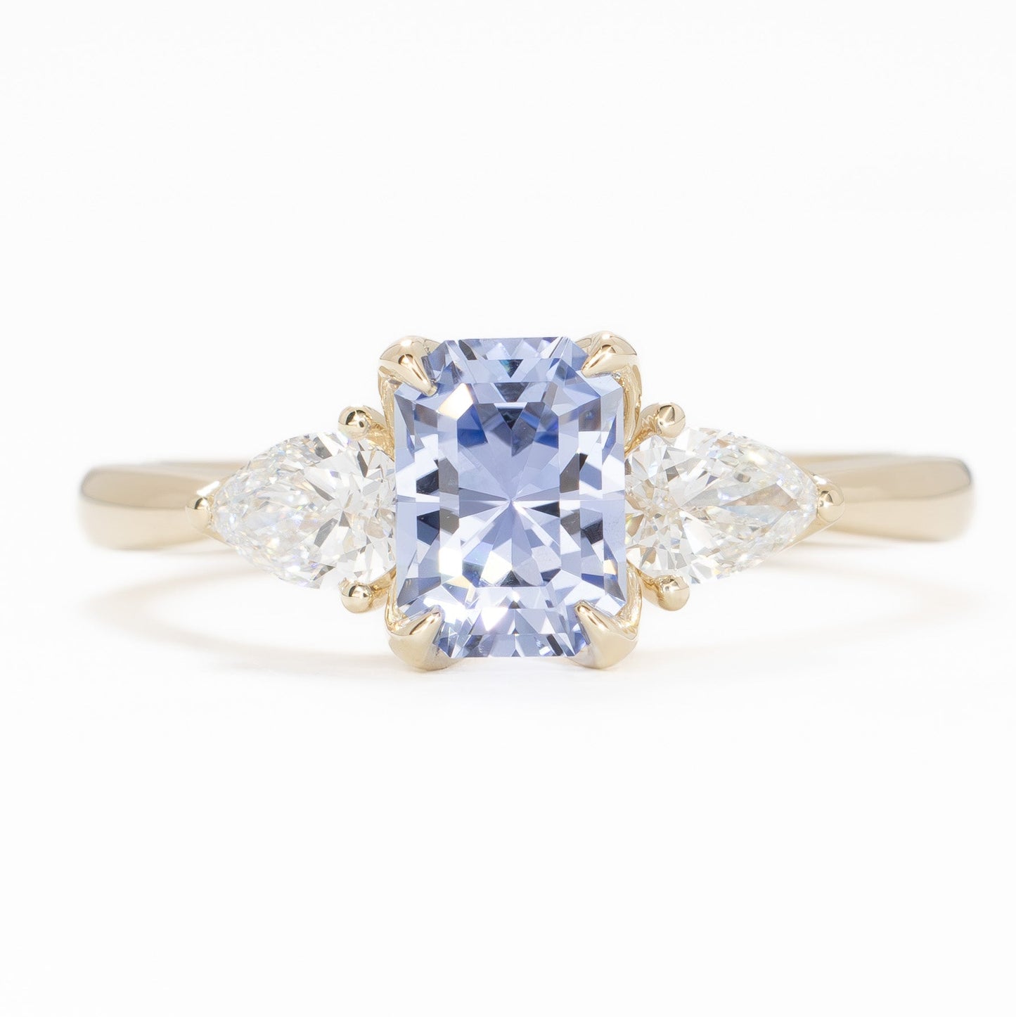 tawnee three stone engagement ring in yellow gold and blue lab sapphire radiant