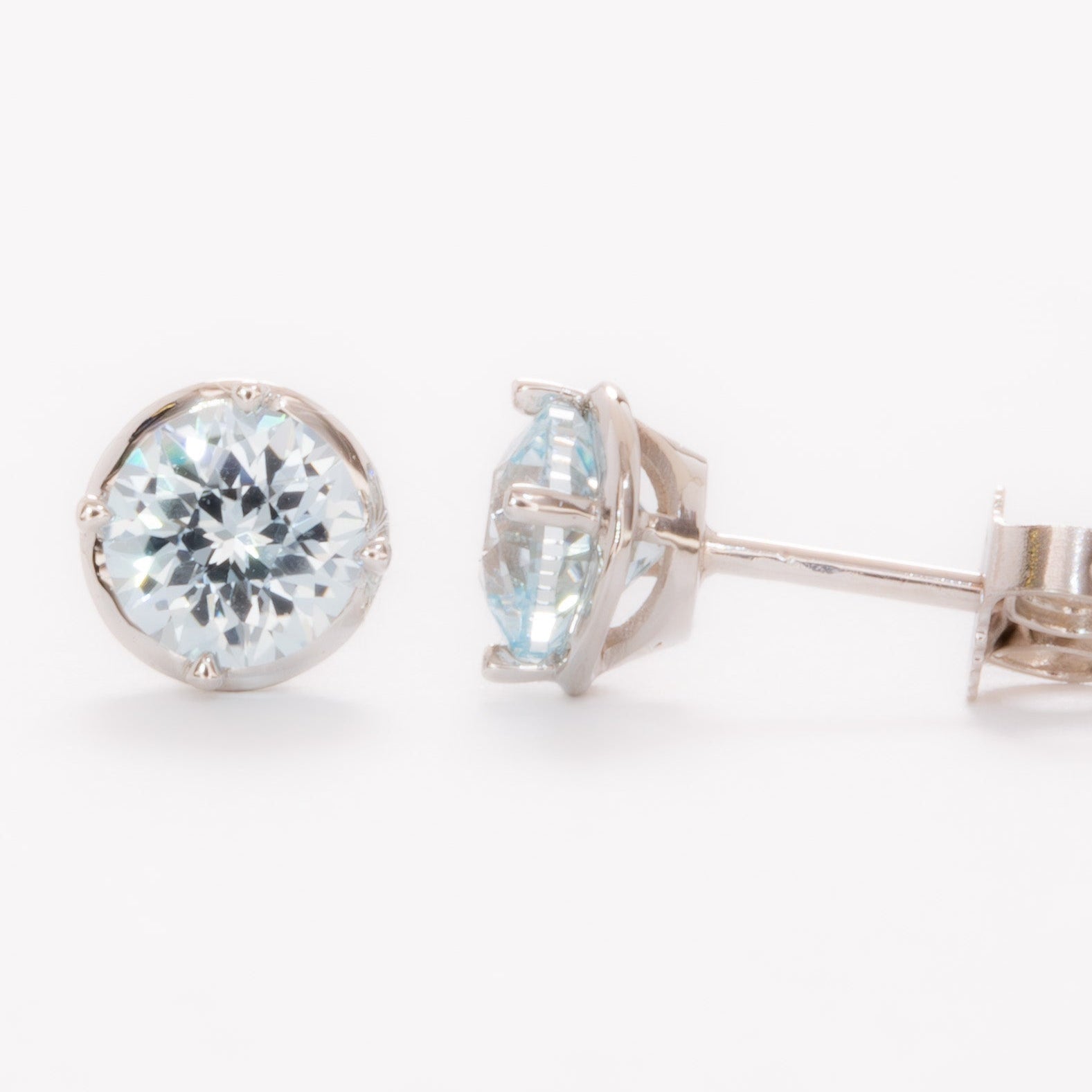 white gold earrings with light blue round lab sapphires